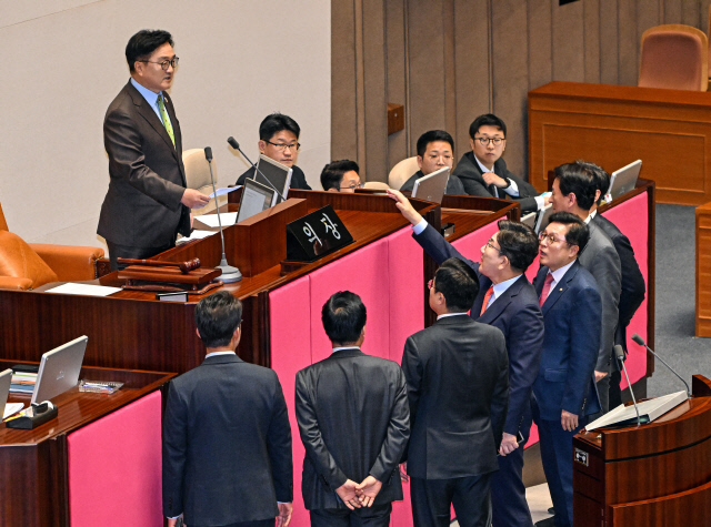 우원식 국회의장이 24일 국회 본회의에서 한덕수 대통령 권한대행 국무총리의 추가경정예산안 시정연설 뒤 한 권한대행에 대한 발언을 하자 국민의힘 권성동 원내대표가 연단 앞으로 나와 우 의장에게 항의하고 있다. [연합뉴스]